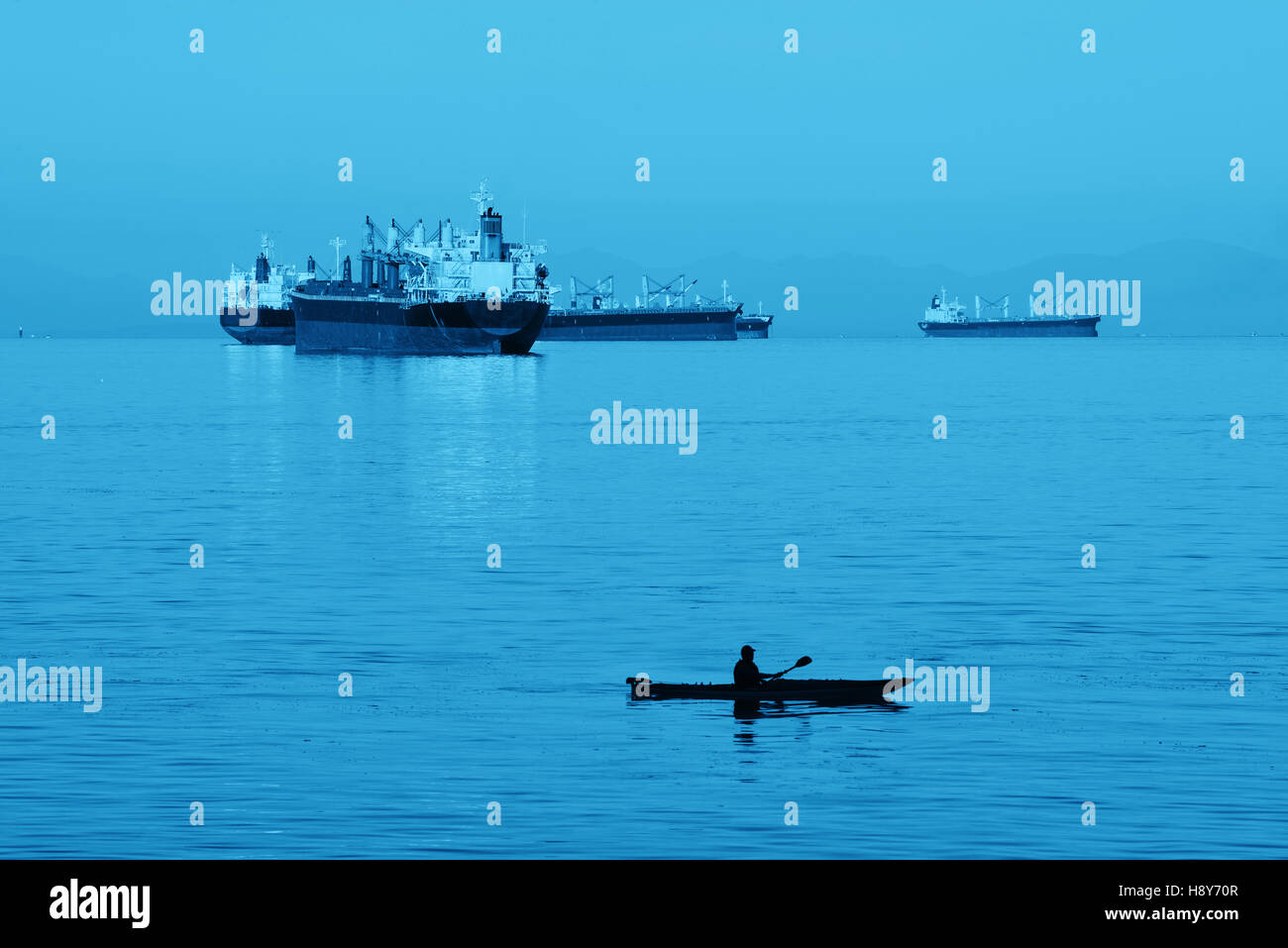 D'un cargo en mer et canoë au lever du soleil à Vancouver. Banque D'Images