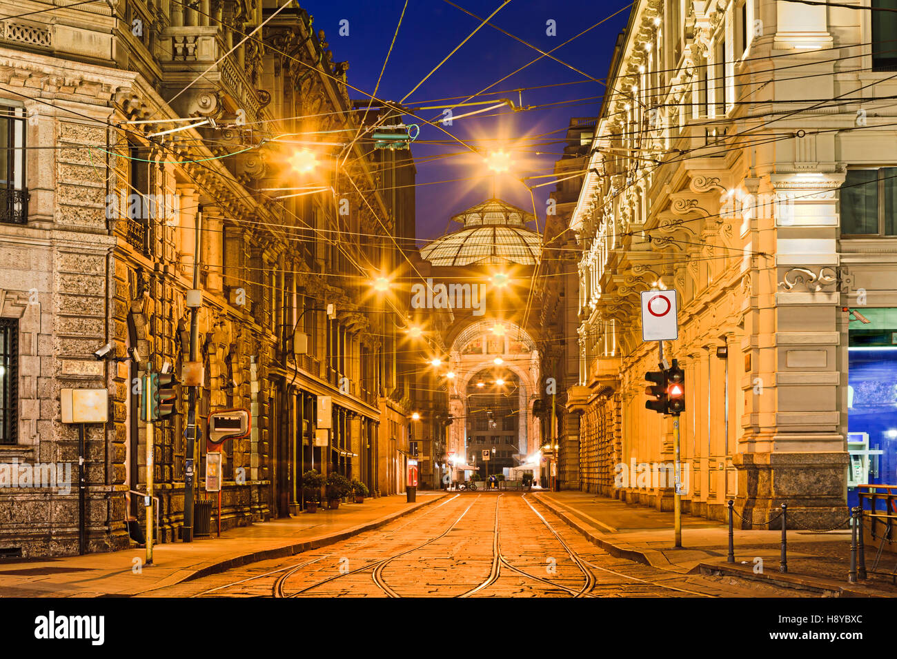 Milan l'street dans le centre-ville historique avec le tramway et les fils au lever du soleil entre le baroque architecture maisons et rue piétonne pavée-s Banque D'Images