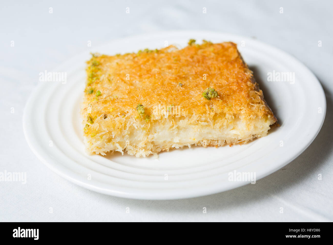 Close-up of dessert Kunafa en arabe sur un fond blanc Banque D'Images