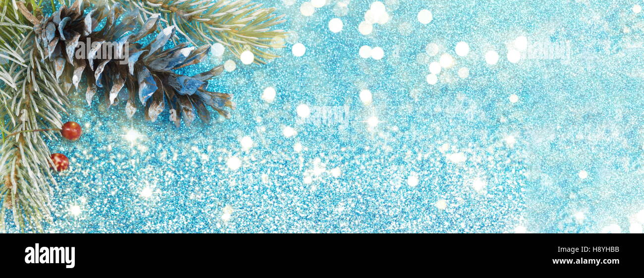 Pommes de Pin et sapin sur fond bleu pétillant. Bannière large décoration de Noël Banque D'Images
