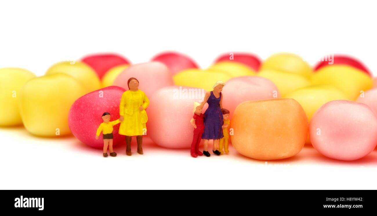 Figurine miniature de la mère et de l'enfant debout à côté de la sucrerie ou bonbon Banque D'Images