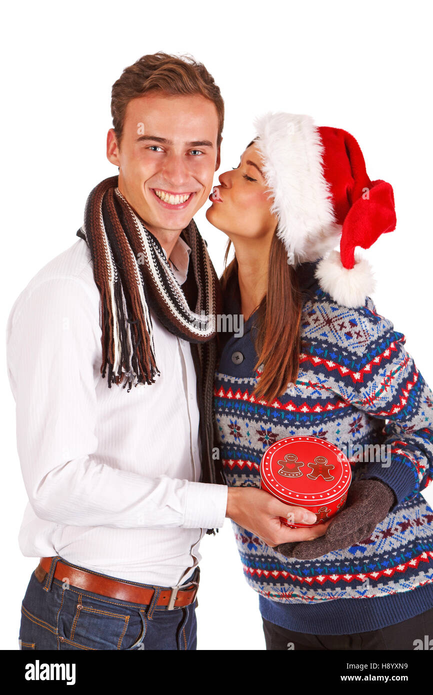 Girl in santa hat kissing boy, fond blanc, studio shot Banque D'Images