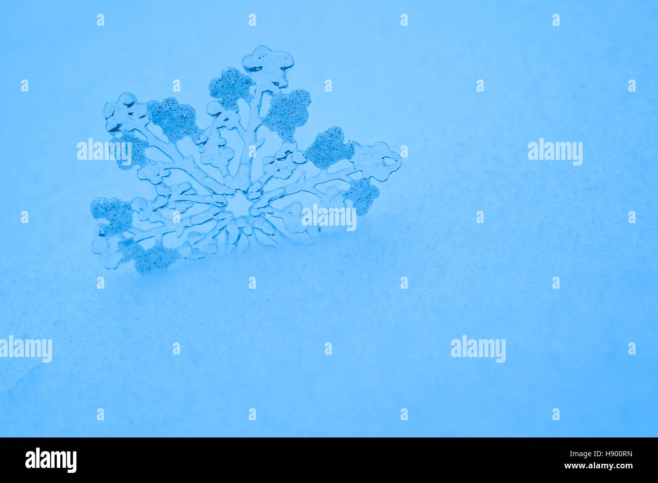 Gros flocon de jouet dans la neige en bleu Banque D'Images