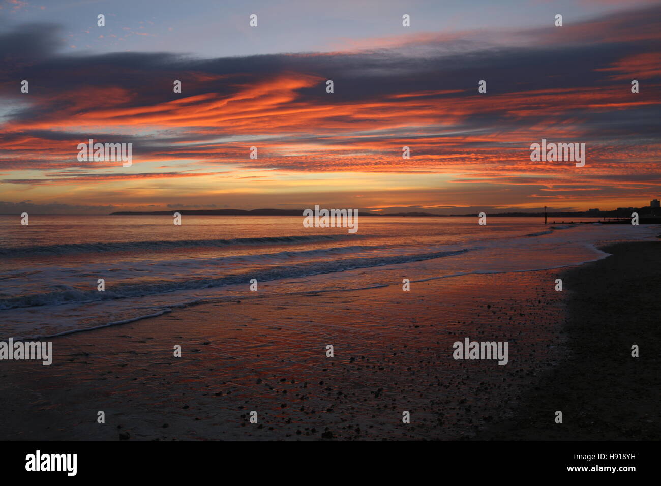 Southbourne beach à Bournemouth, Dorset, England, UK. Le spectaculaire coucher du soleil d'automne présente des couleurs chaudes sur la baie de Poole. Banque D'Images