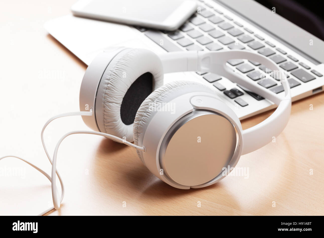 Plus de casque de l'ordinateur portable sur un bureau en bois table. Concept Musique Banque D'Images