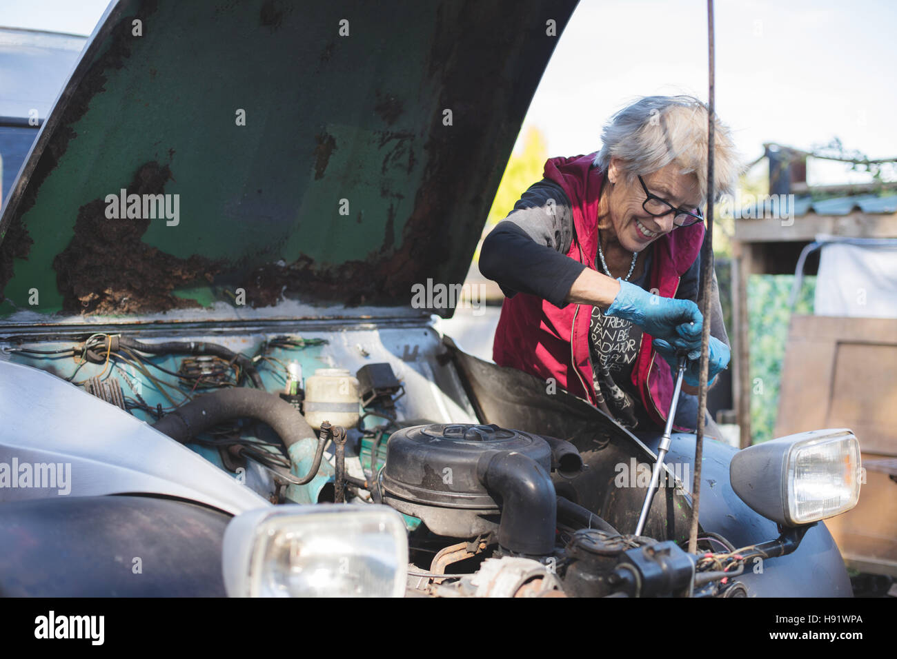 Personnes âgées mécanicien travaillant sur son vintage car Banque D'Images