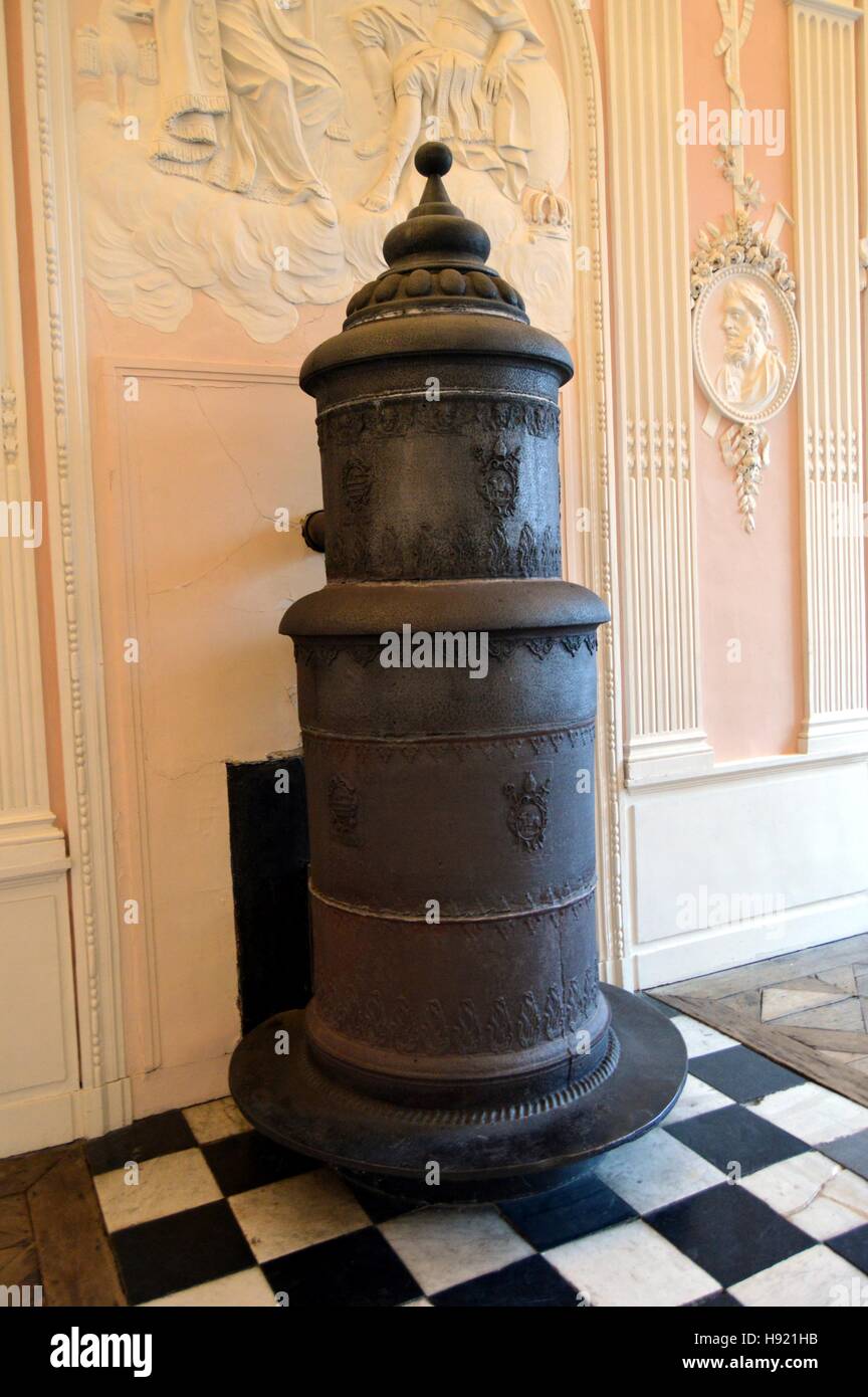 Ancien poêle à bois en fonte et de la colonne en face d'un mur rose Banque D'Images