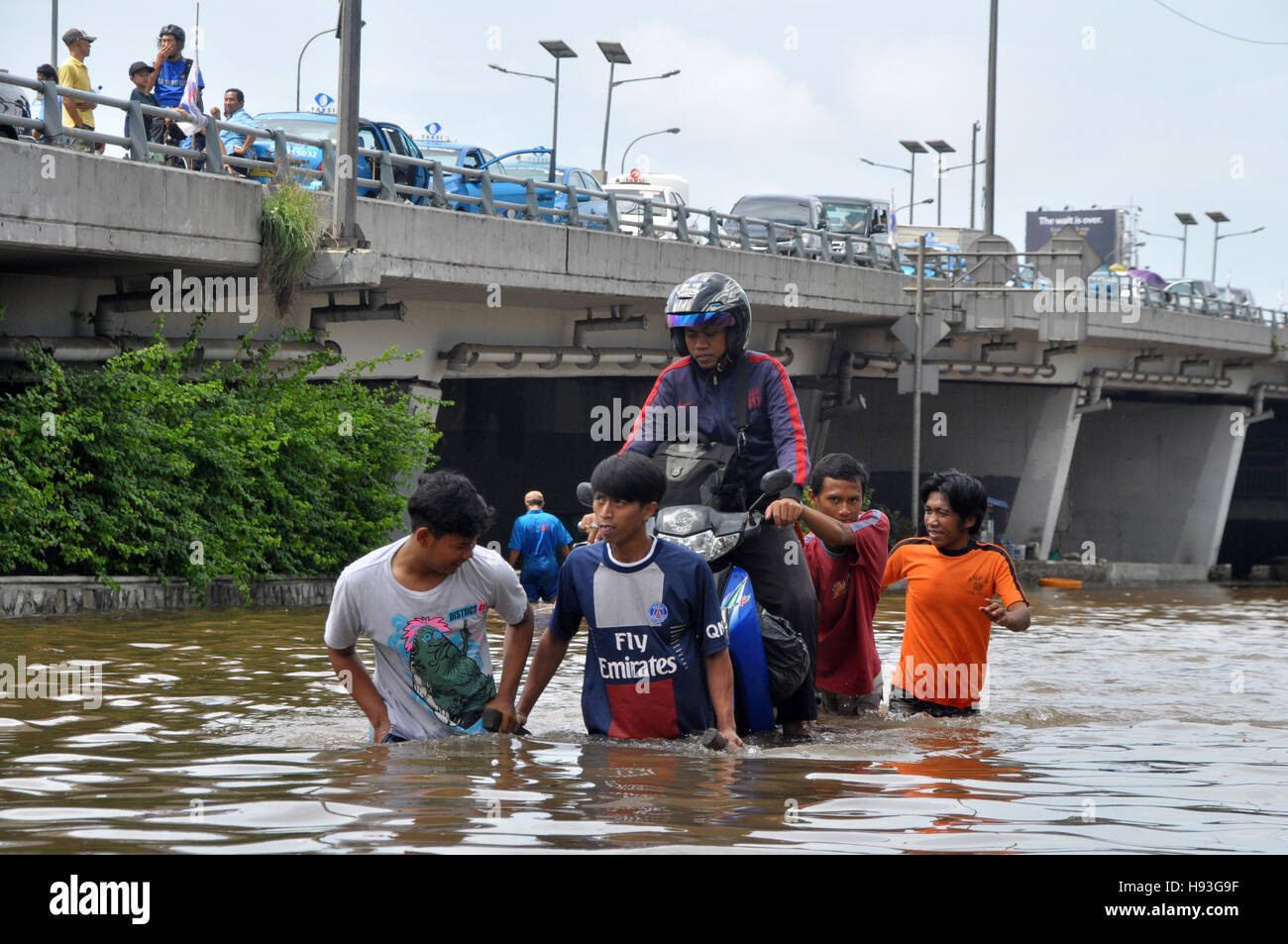Jakarta, Indonésie - 10 Février 2015 : Les Motocyclistes briser la rue inondation à l'aide d'un chariot à Jakarta, Indonésie. Banque D'Images