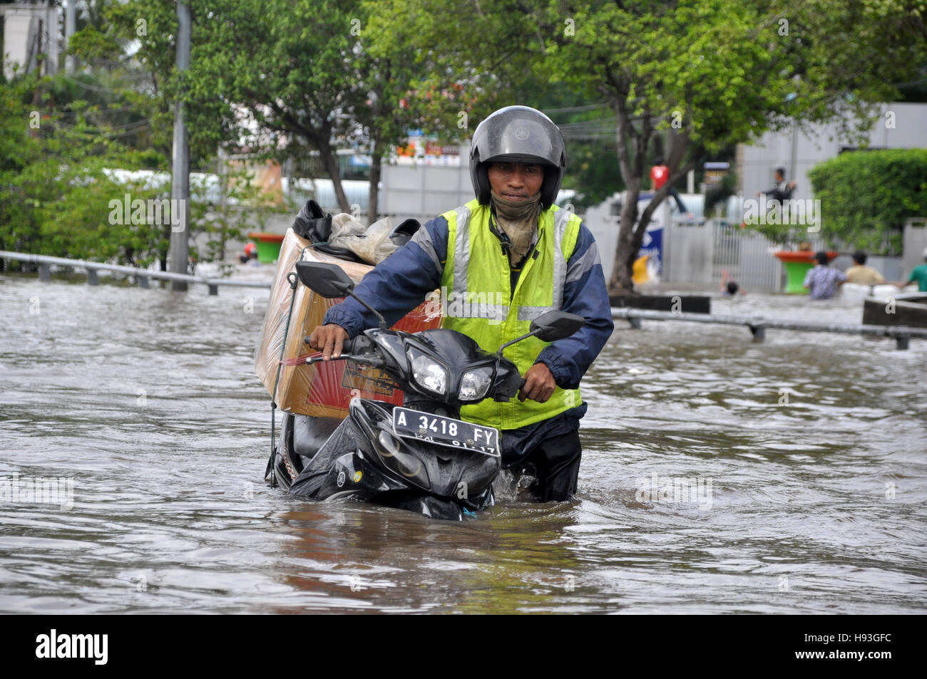 Jakarta, Indonésie - 10 Février 2015 : résident de Jakarta avec sa moto à travers l'inondation street à Grogol, Jakarta, Indonésie. Les fortes pluies ca Banque D'Images
