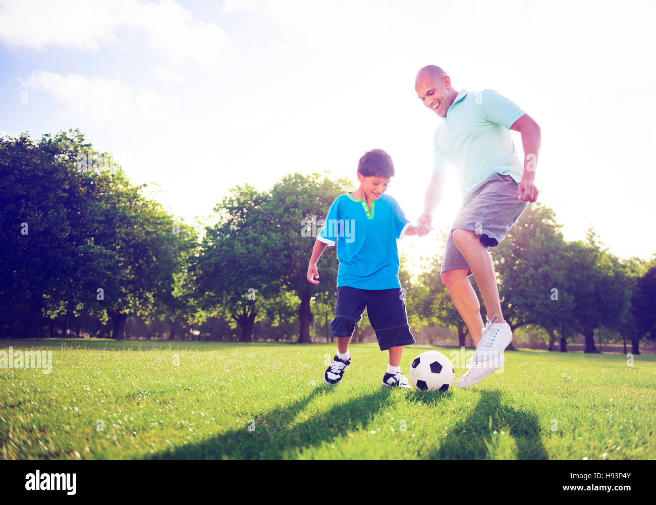 Petit Garçon jouant au football avec son père Concept Banque D'Images