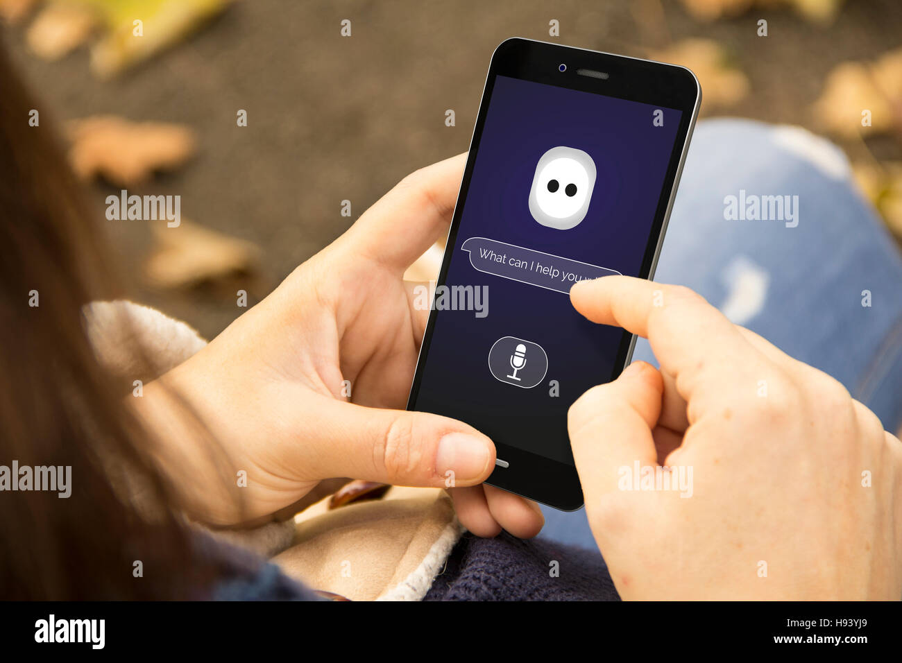 Jeune femme avec un assistant intelligent téléphone demande au parc. Tous les graphiques de l'écran sont composés Banque D'Images