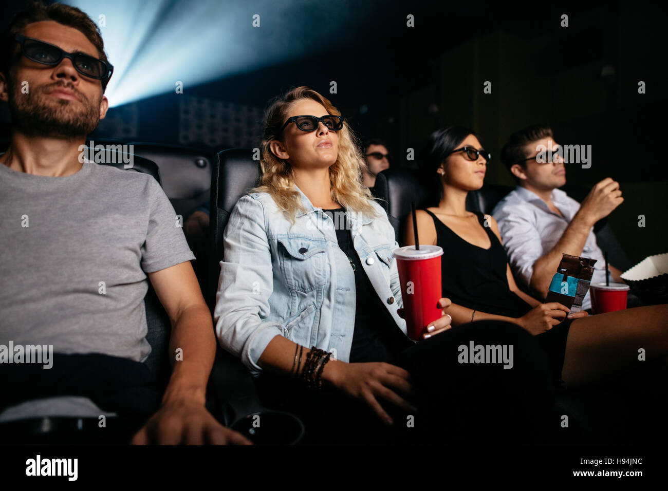 Groupe de personnes dans les lunettes 3D Regarder la vidéo dans le cinéma.  Les hommes et les femmes avec un verre le visionnage en 3d film Photo Stock  - Alamy