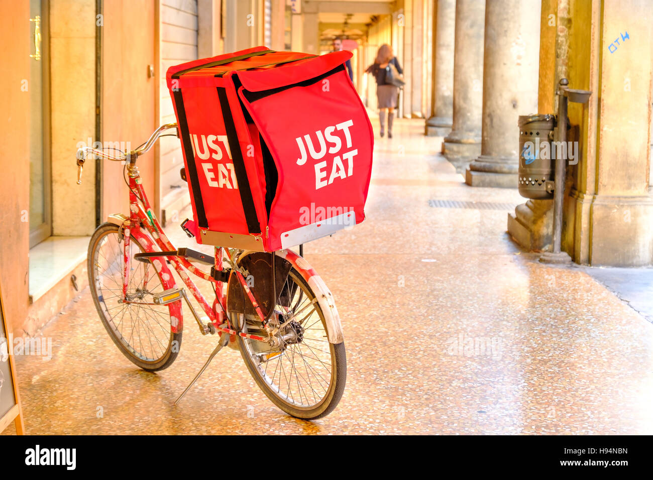 Mangez juste conteneur sur un vélo utilisé pour les livraisons sous le Bologna's portiques. Mangez juste une commande de repas en ligne s et Banque D'Images