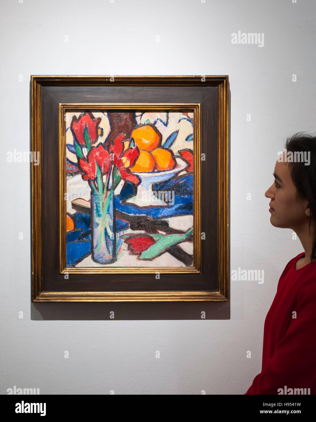 Londres, Royaume-Uni. 18 Nov, 2016. Un membre du personnel vues "toujours la vie avec les tulipes et les oranges' par Samuel John Peploe (est. GBP250-350k), à l'aperçu à Sotheby's d'œuvres à quatre prochaines enchères Novembre dispose d''Art Moderne et d'art britannique d'après-guerre, A Painter's Paradise (Julian Trevelyan & Mary Fedden au quai de Durham), l'Art écossais et Picasso La céramique du Lord et Lady Attenborough Collection privée. Crédit : Stephen Chung/Alamy Live News Banque D'Images