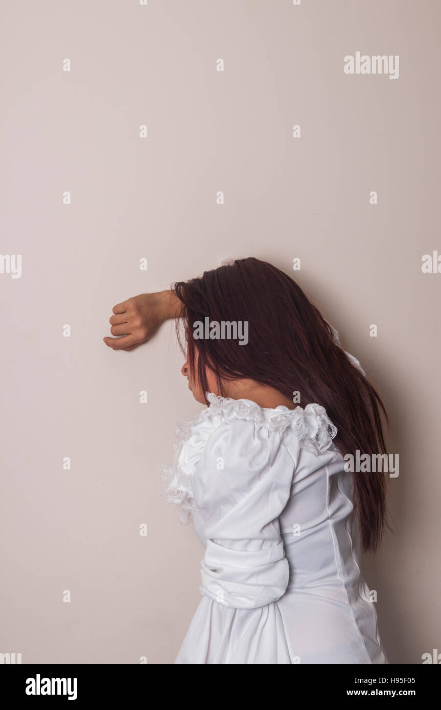 Femme misérable appuyé contre le mur Banque D'Images