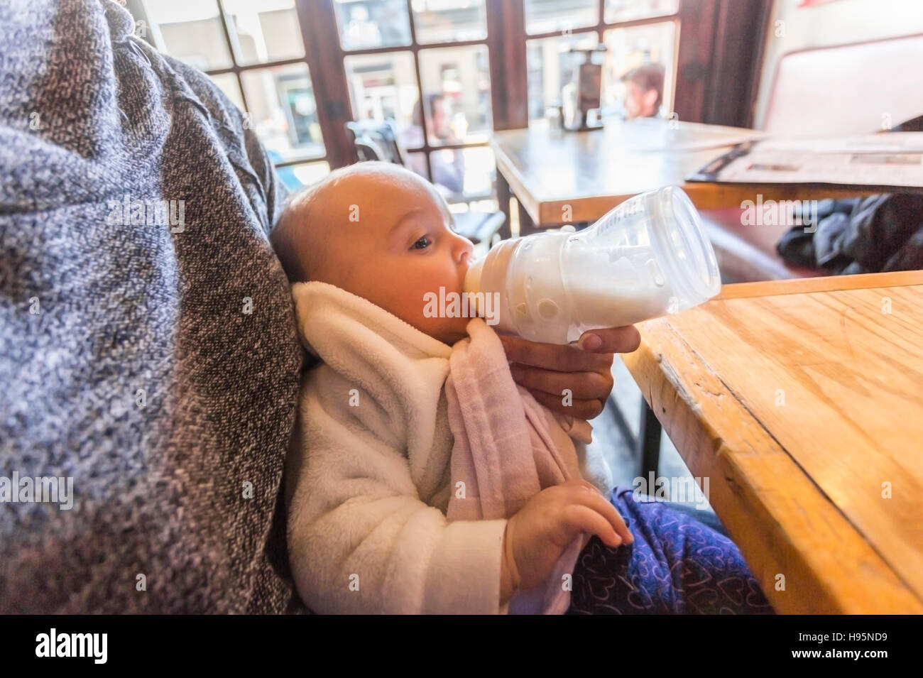Mère biberon 5 mois baby girl in restaurant Banque D'Images