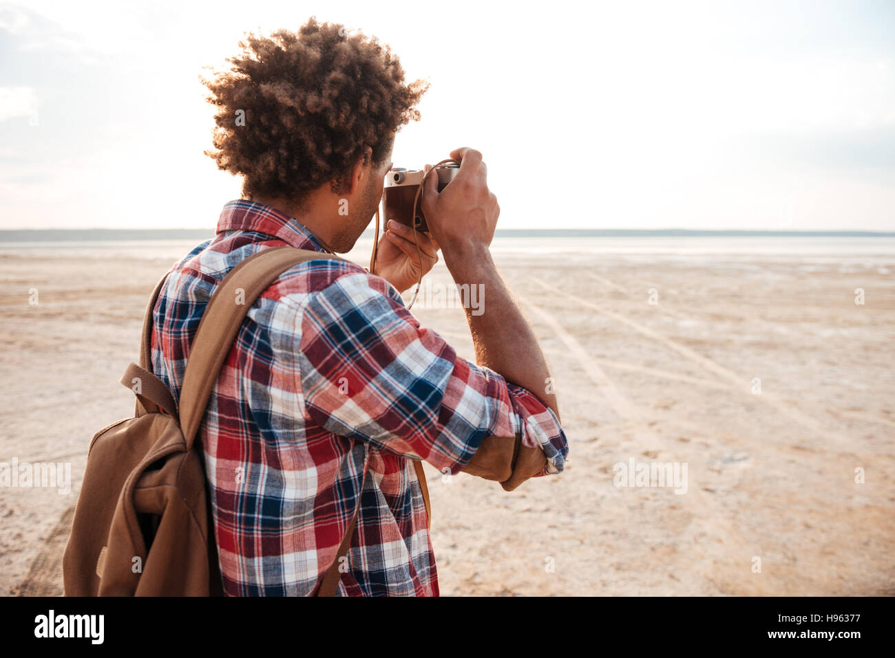Vue arrière de l'african american man sac à dos avec prise de photos sur la  plage Photo Stock - Alamy