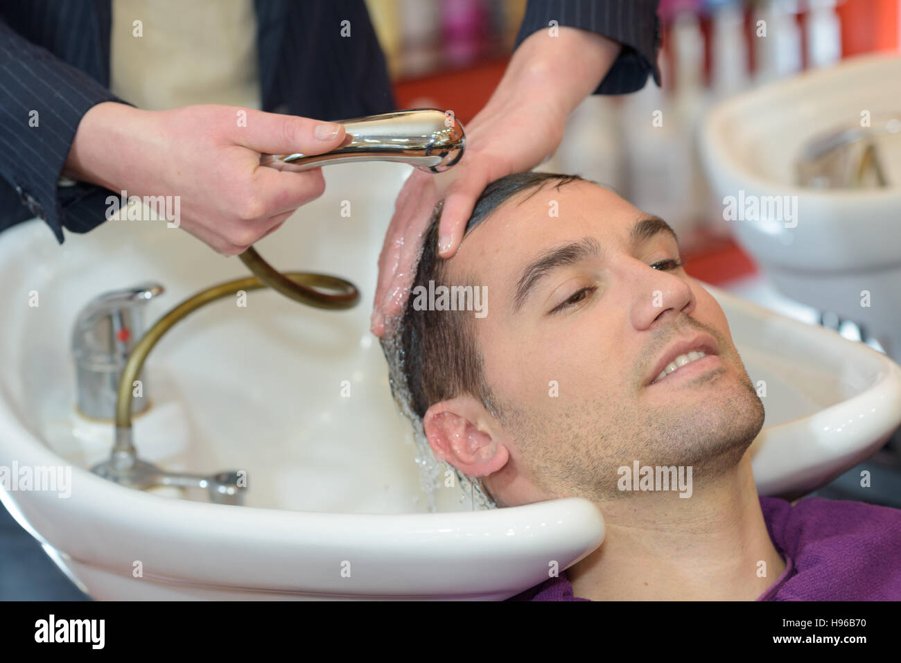 Après avoir lavé les cheveux de l'homme dans les coiffeurs Banque D'Images