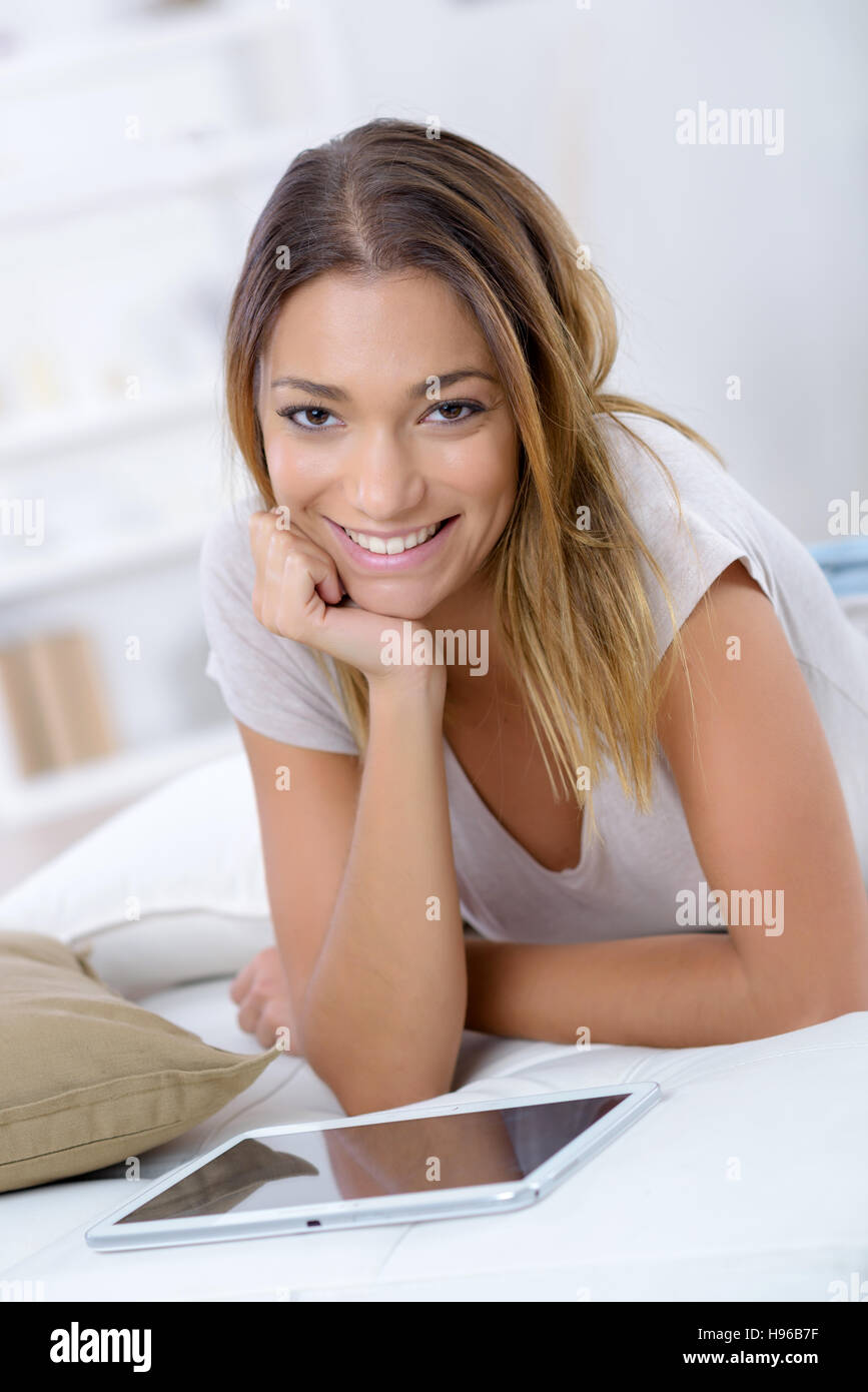Portrait of a smiling young woman using tablet à l'intérieur Banque D'Images
