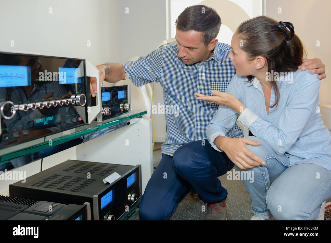 Couple looking at sound systems Banque D'Images