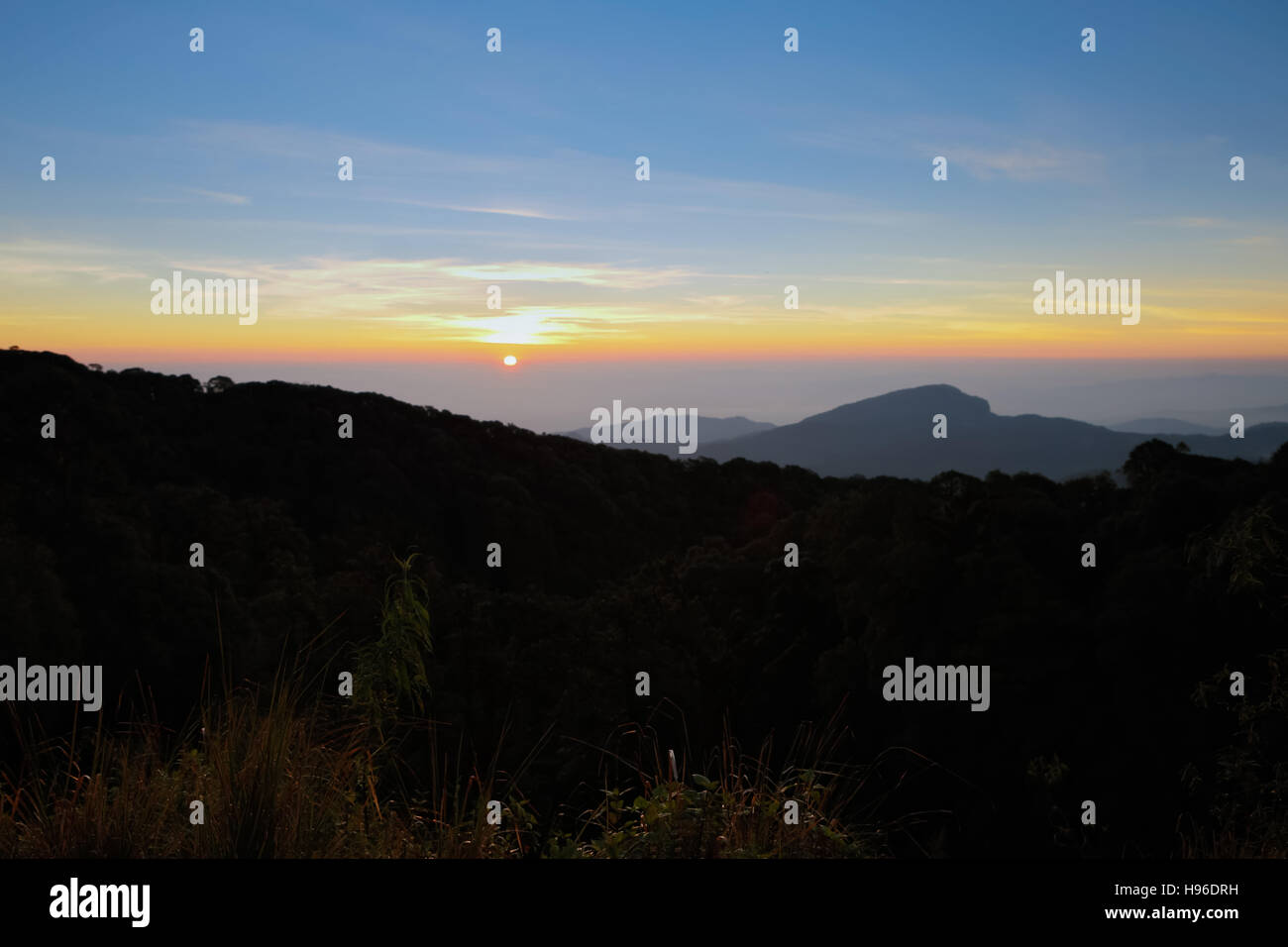 Paysage de forêts de montagne sous matin ciel avec nuages dans la lumière du soleil Banque D'Images