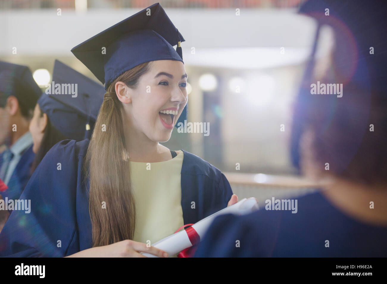 Diplômé de l'université féminine enthousiaste à cap and gown Banque D'Images