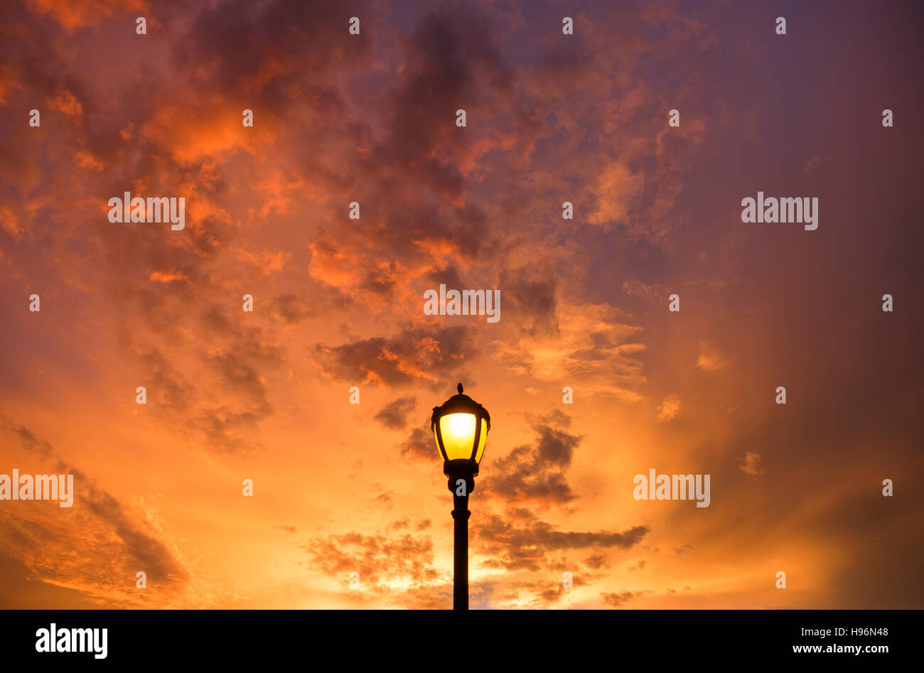 Ciel coucher de soleil spectaculaire avec un lampadaire en premier plan Banque D'Images
