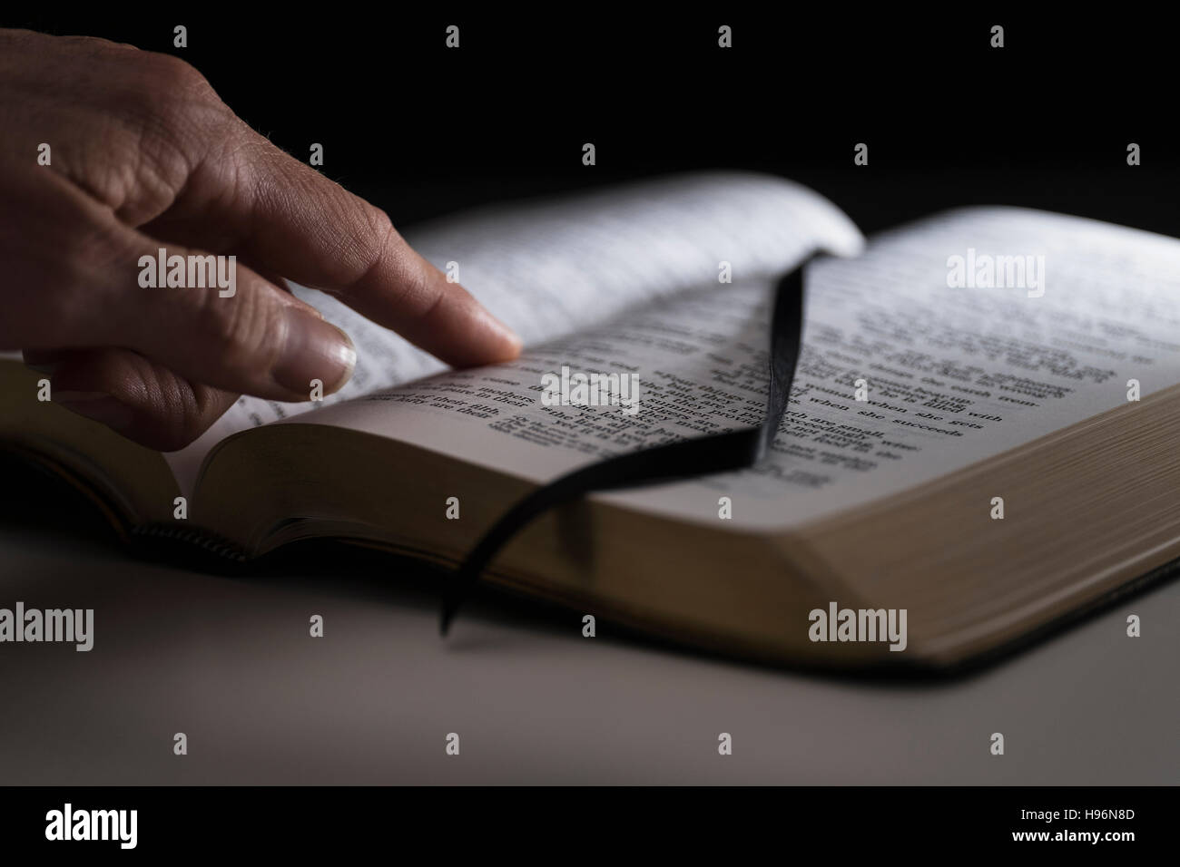 Doigt sur la Bible ouverte Banque D'Images