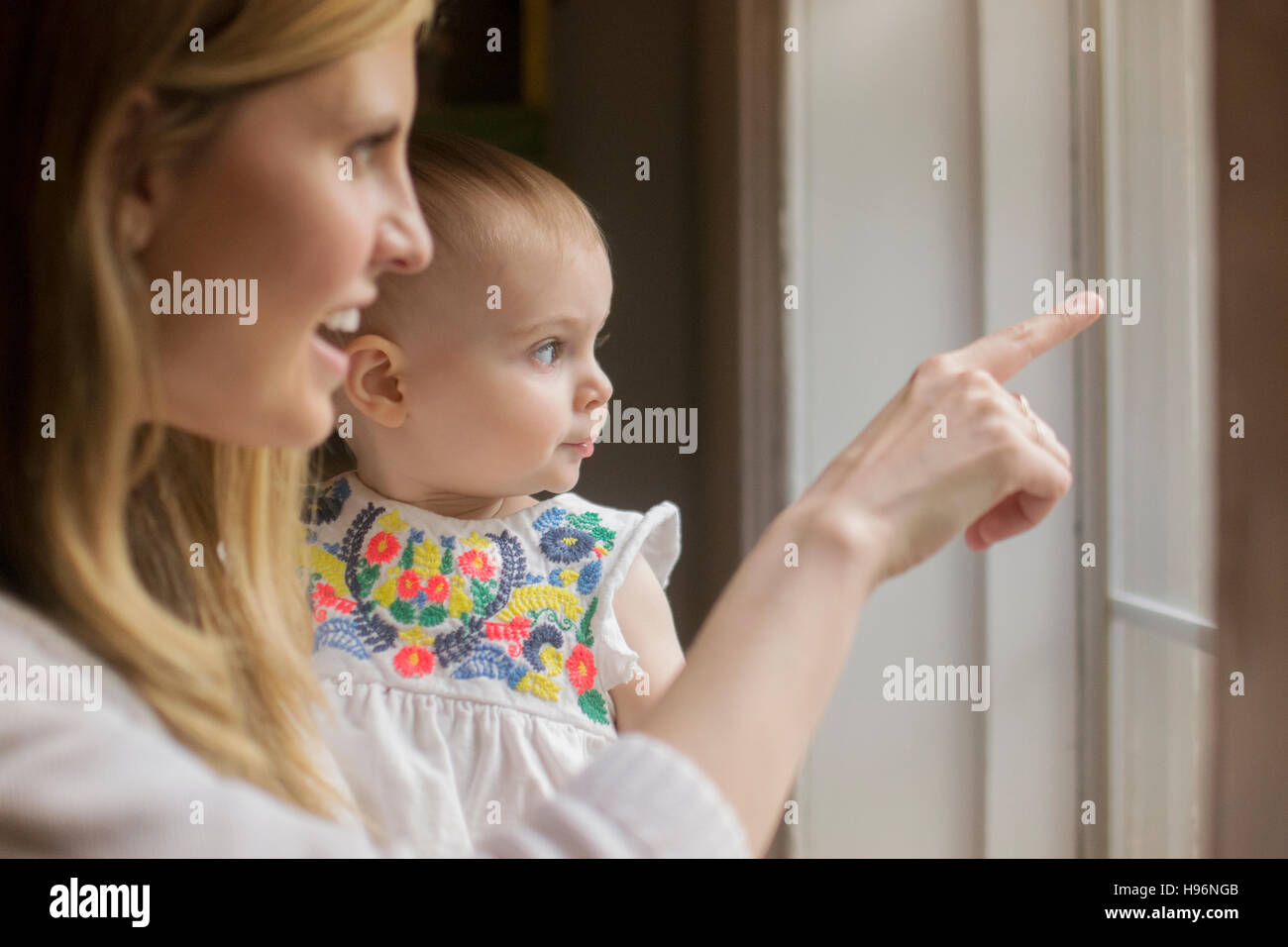 Mère et fille (18-23 mois) à la recherche d'une fenêtre Banque D'Images