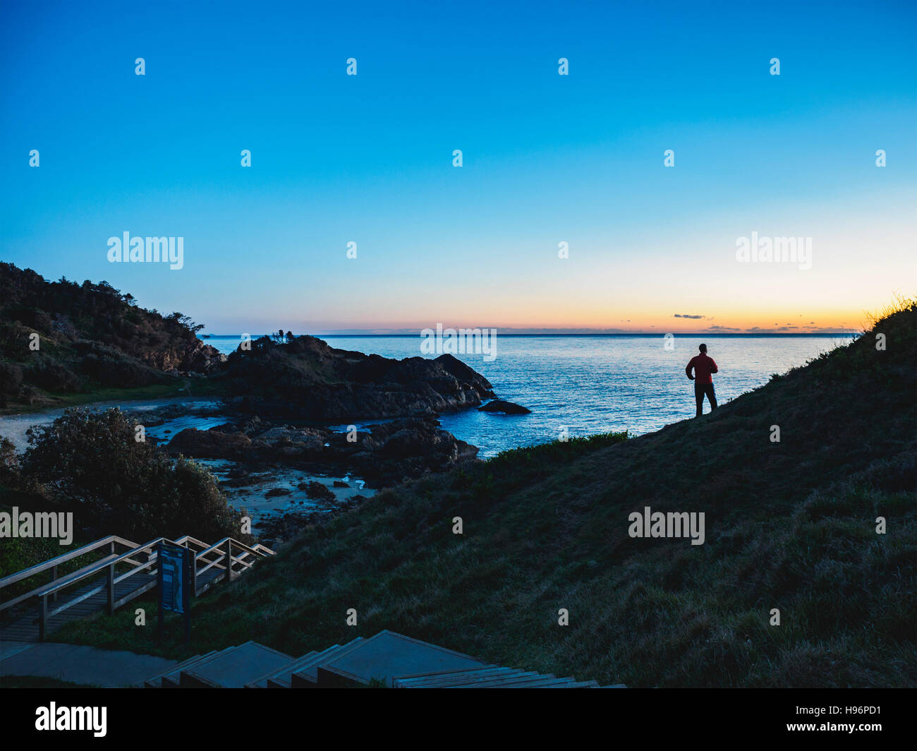 L'Australie, Nouvelle Galles du Sud, Port Macquarie, Silhouette de l'homme à la recherche en mer au lever du soleil Banque D'Images