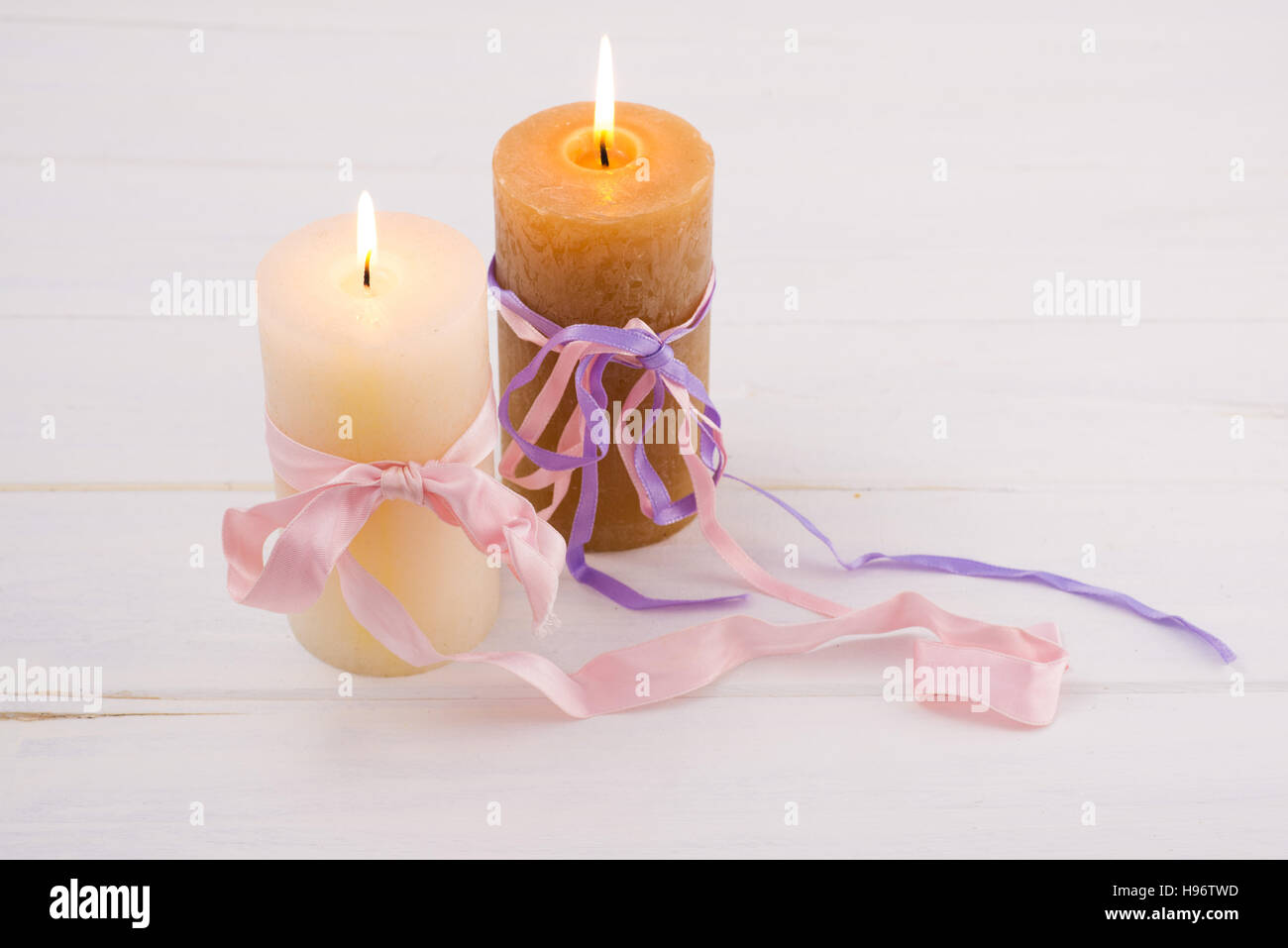 Les bougies et les rubans sur une table en bois blanc Banque D'Images
