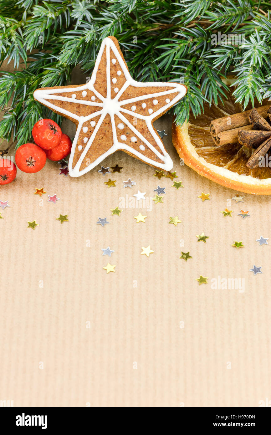 Maison de Noël en forme d'étoile d'épices, fruits rouges et le sapin arbre branche sur fond de papier rayé marron Banque D'Images
