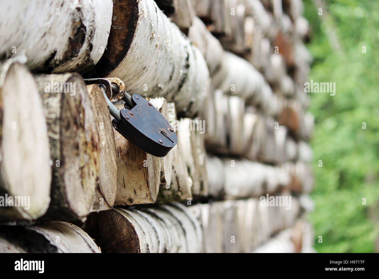 Grumes de bouleau de texture pattern empilés sur les murs de la maison et verrouiller les volets métalliques sur les fenêtres. Banque D'Images