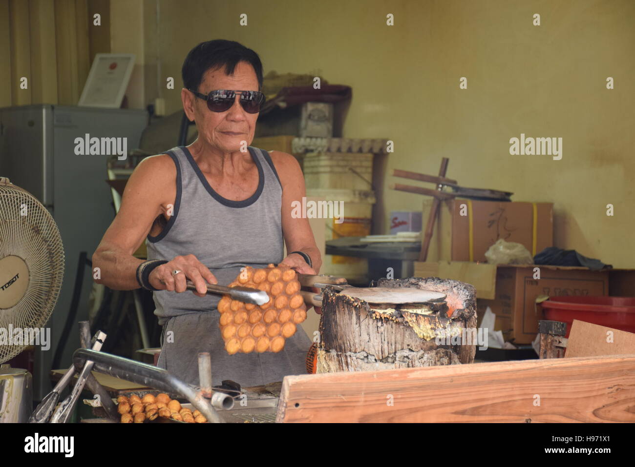 Old asian man la préparation d'un dessert typiquement chinois à l'intérieur de son magasin à l'île de Lantau, Hong Kong - Chine Banque D'Images