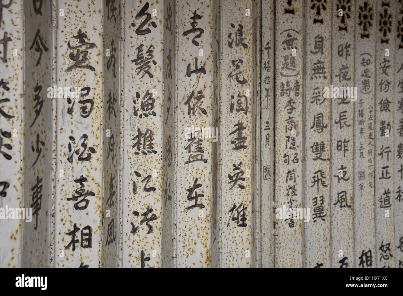 Caractères chinois sur un mur de panneaux de métal blanc Banque D'Images
