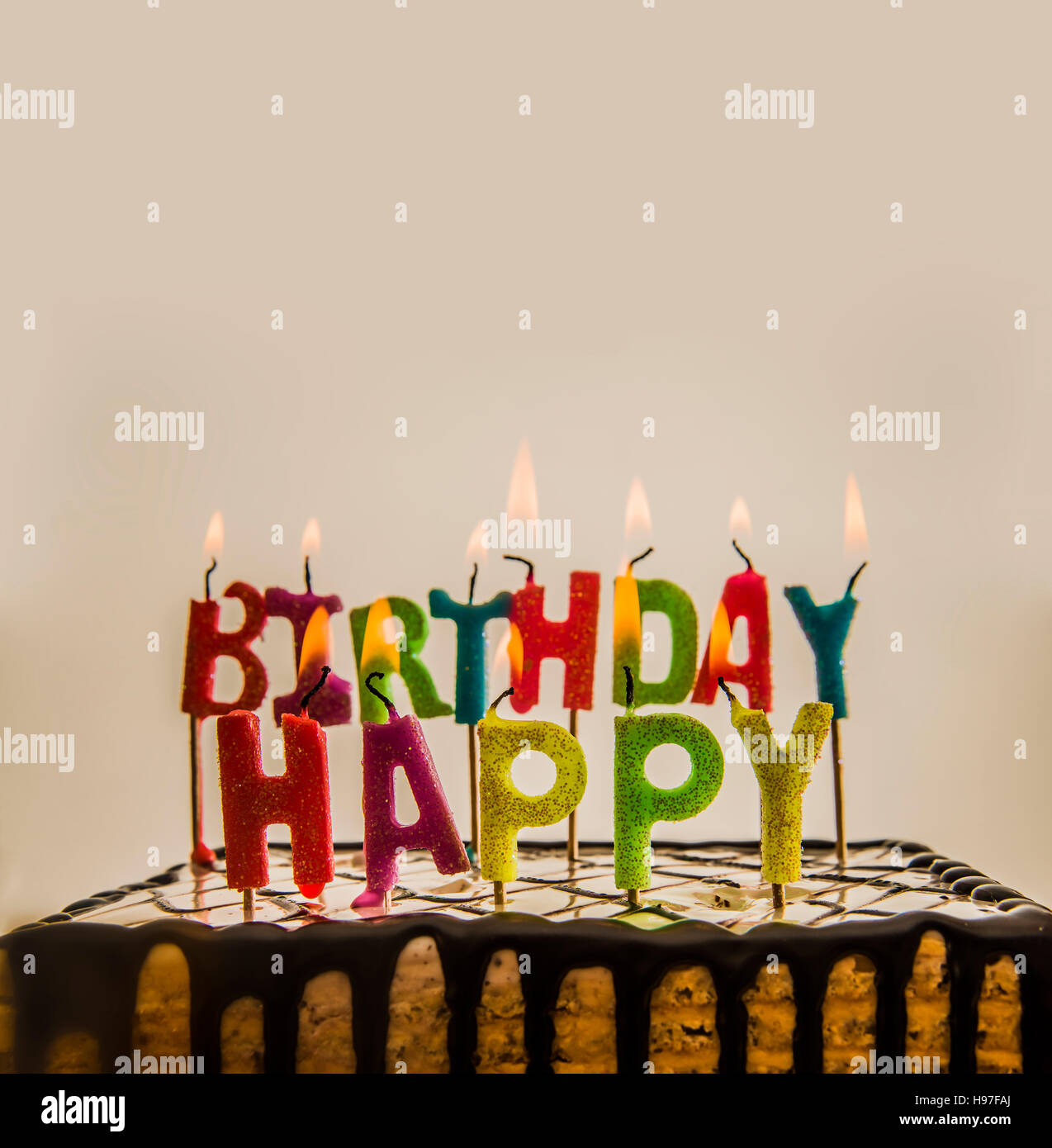 Joyeux anniversaire bougies sur un gâteau au chocolat isolé sur fond blanc ou gris. Banque D'Images