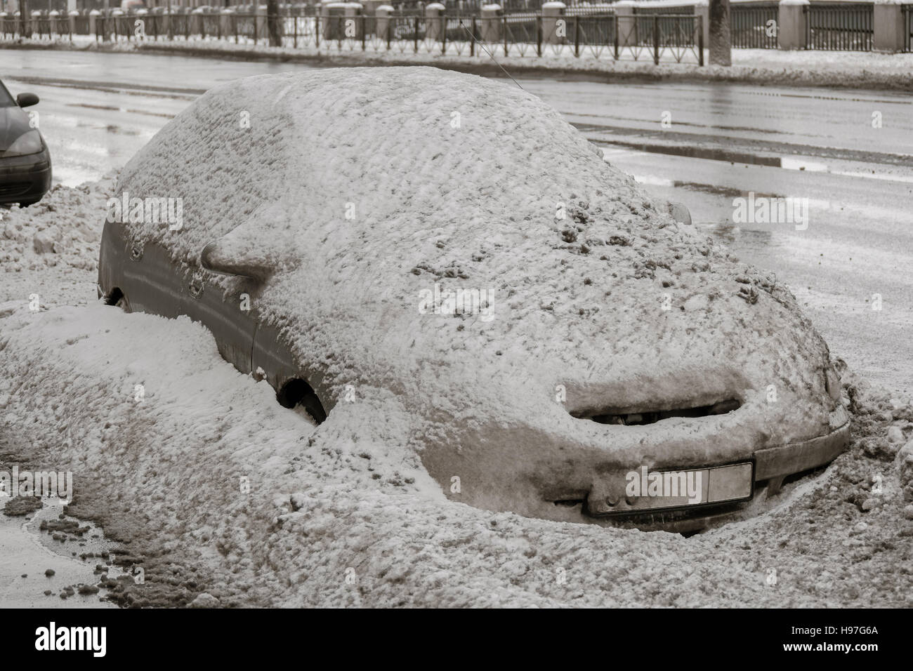 Voiture sur la route d'hiver couverte de neige. Véhicule sur ruelle enneigée le matin après les chutes de neige dans la ville. Banque D'Images