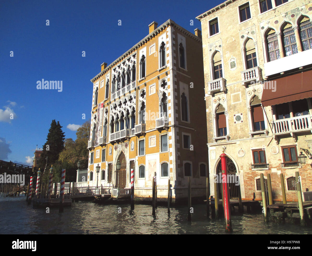 Belle architecture traditionnelle avec des poteaux d'amarrage contre ciel bleu vif de Venise, Italie Banque D'Images