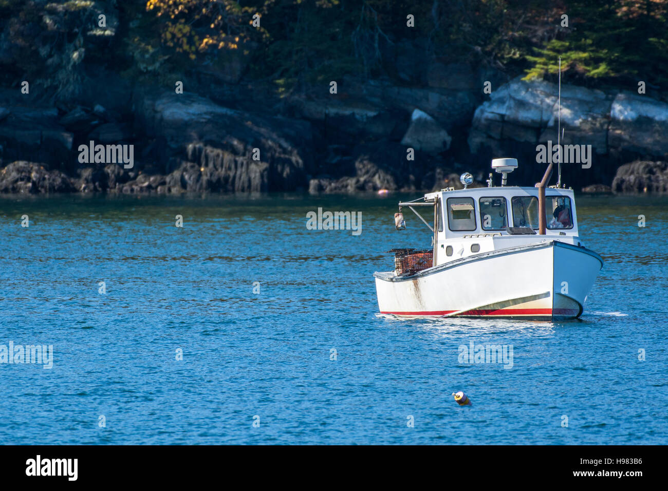 Bateau de pêche au homard à l'automne contre l'eau de l'océan bleu profond sur la côte du Maine, New England Banque D'Images