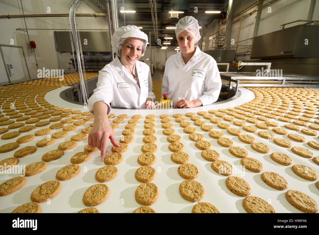 Ligne de production avec des biscuits et des ouvriers d'usine Banque D'Images