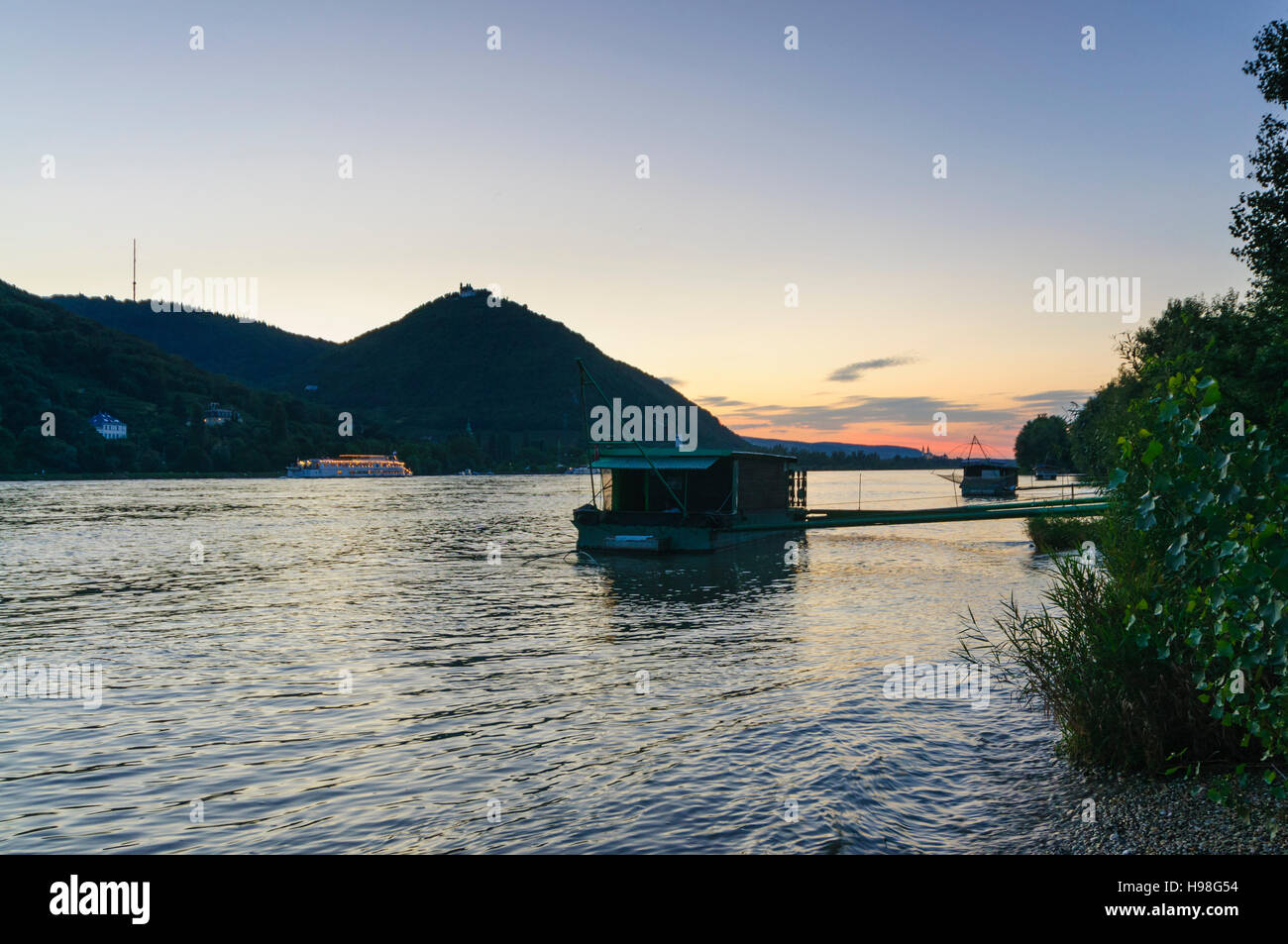 Wien, Vienne : bateau de pêche bateaux avec Daubel (net) sur le Danube, montagnes Kahlenberg et Leopoldsberg au coucher du soleil, 19, Wien, Autriche. Banque D'Images