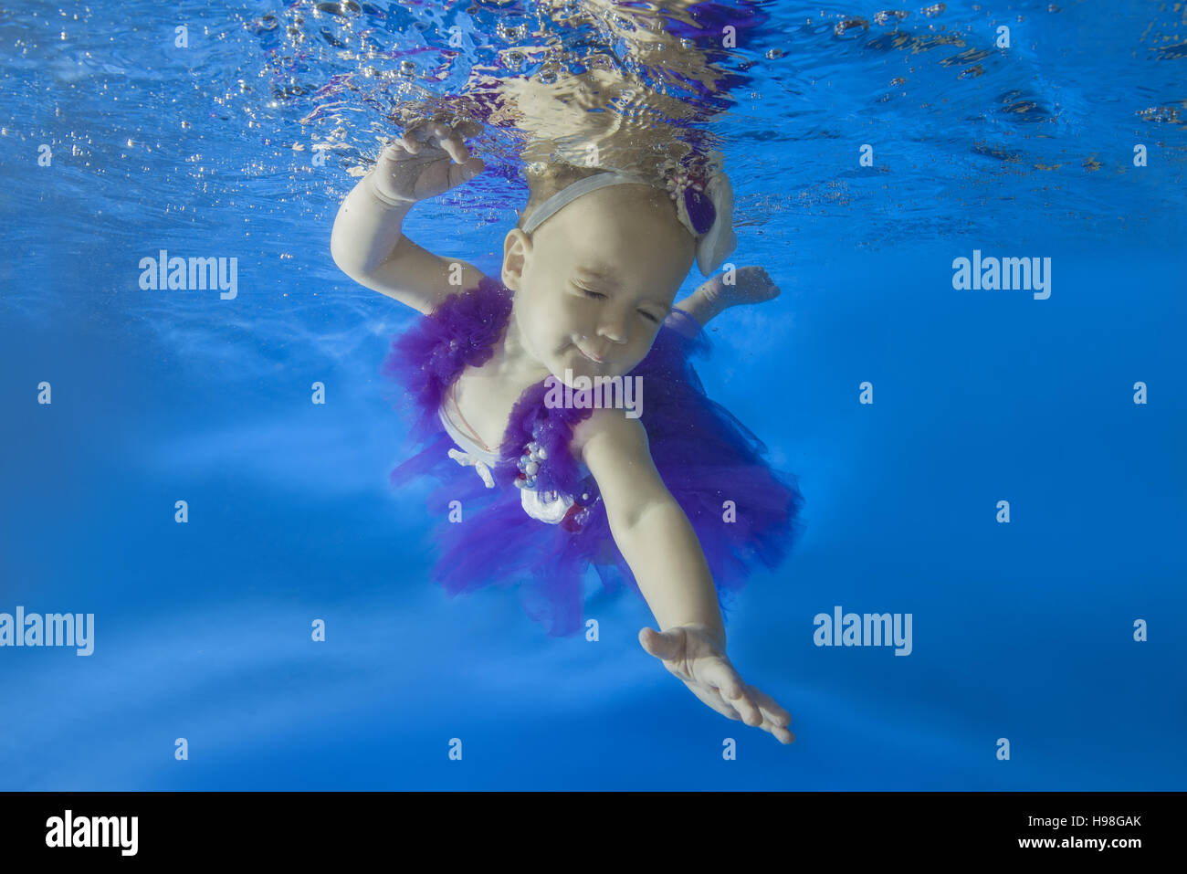 Petite fille dans une robe ballerine flotte sous l'eau dans la piscine  Photo Stock - Alamy