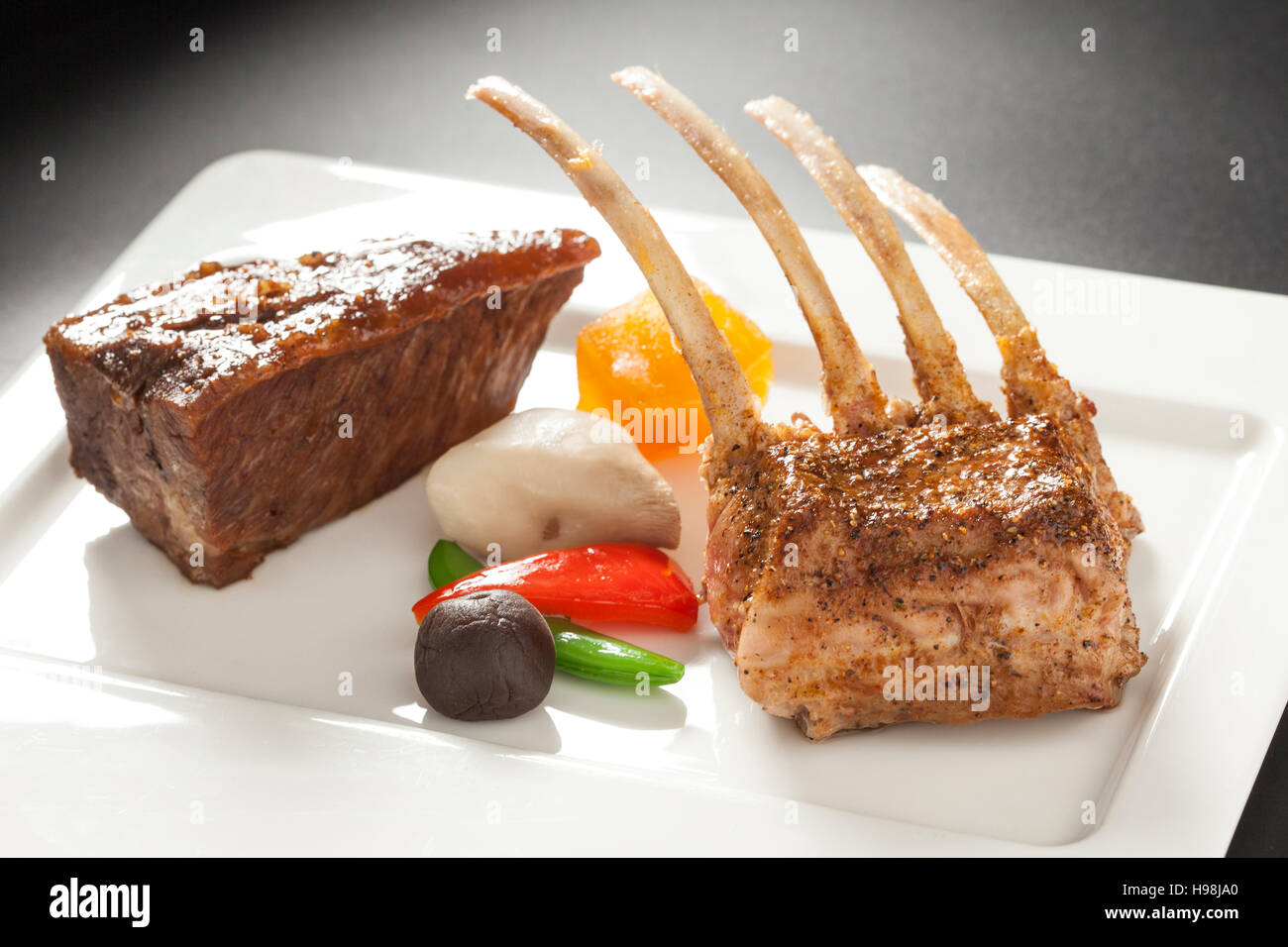 Carré d'agneau rôti côtelettes rectangle sur le plat blanc en bois Banque D'Images