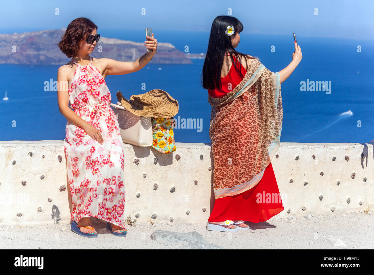 Les touristes asiatiques prenant un selfie avec appareil photo de smartphone au-dessus de caldera, Santorin, île grecque, Grèce touristes Banque D'Images