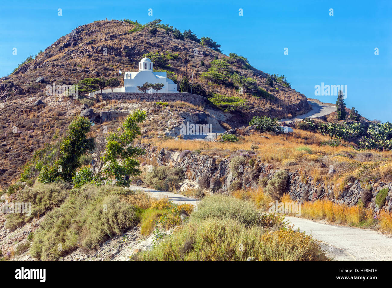 Le chemin - route poussiéreuse de Thira à Oia Santorini Petite église au pied de la colline des îles grecques Paysage grec Banque D'Images