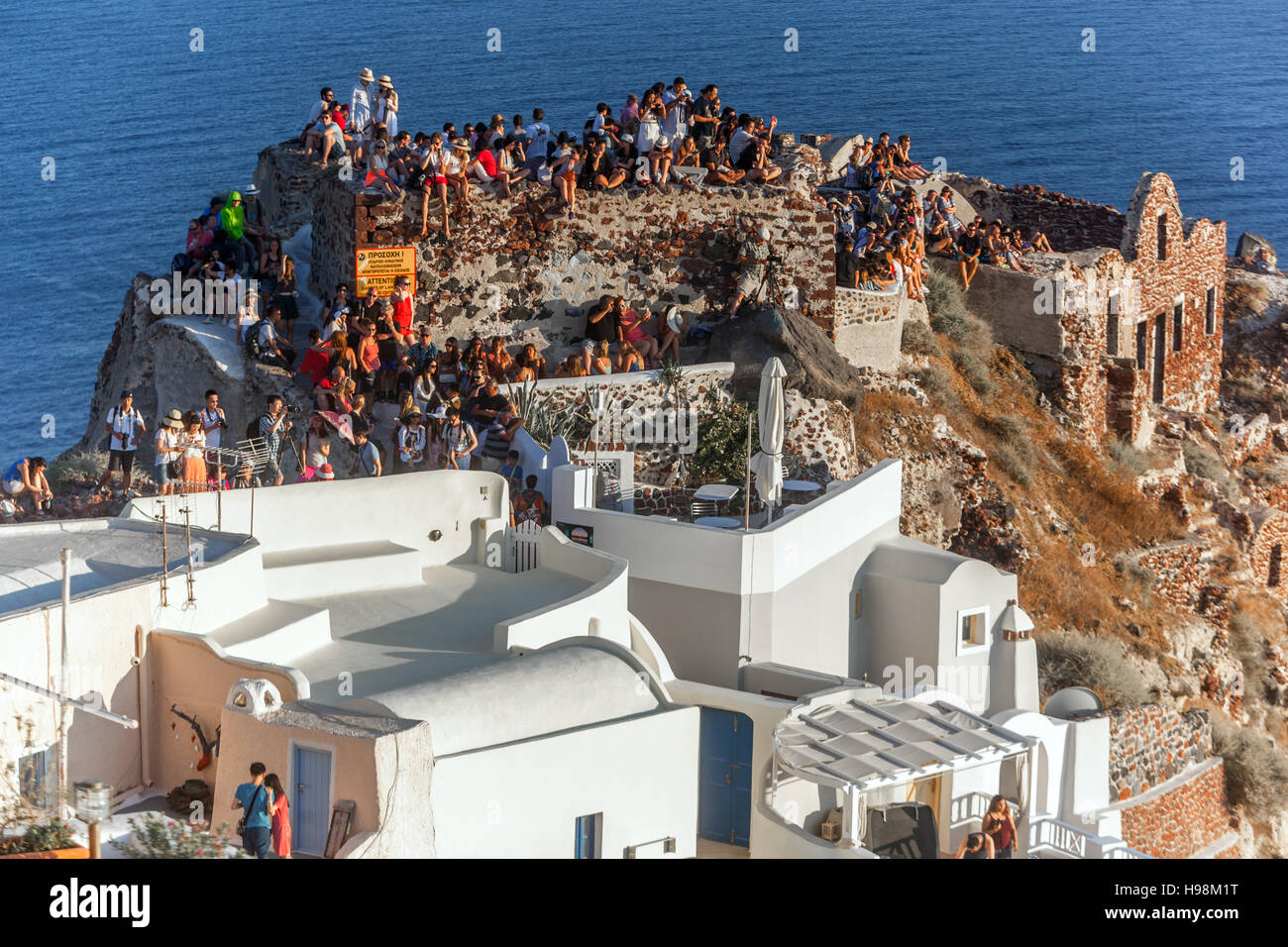 Santorini Grèce Oia château foule de gens touristes en attente le coucher du soleil Banque D'Images