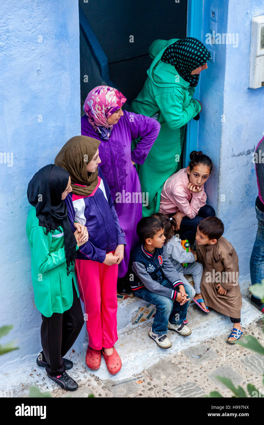 Une famille marocaine à regarder la vie dans leur face de leur porte avant, Chefchaouen, Maroc Banque D'Images