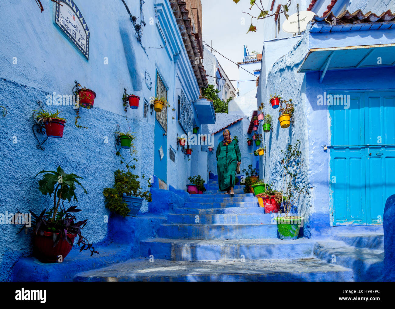 Une femme marchant dans une rue pittoresque de la médina, Chefchaouen, Maroc Banque D'Images