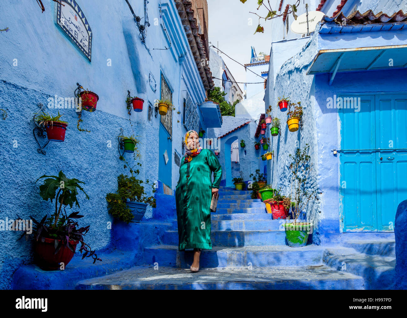 Une femme marchant dans une rue pittoresque de la médina, Chefchaouen, Maroc Banque D'Images