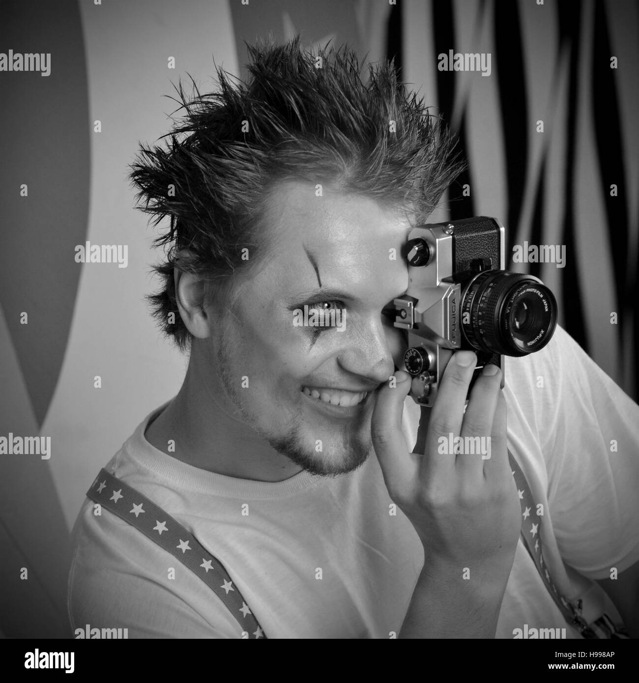 Le rendu noir et blanc de scary clown de cirque en séance et réglage de la caméra Minolta holding Banque D'Images